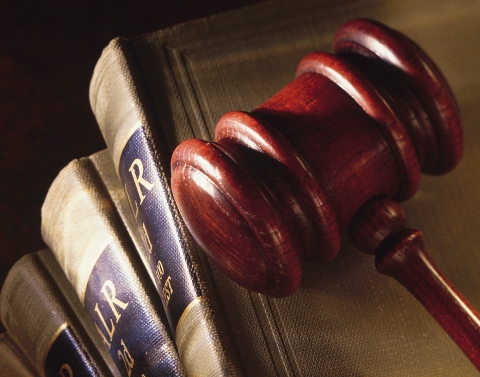 A wooden gavel on top of several legal books