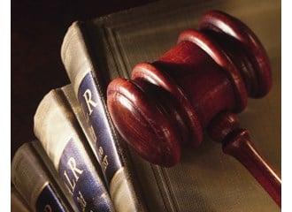 A wooden gavel on top of several legal books