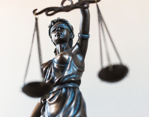 Partial view of the Roman god Lady Justice blindfolded holding a set of scales in one hand