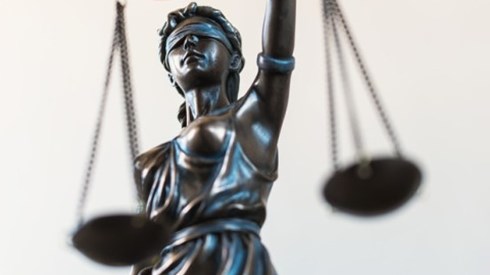 Partial view of the Roman god Lady Justice blindfolded holding a set of scales in one hand