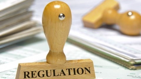 Wood rubber stamp for REGULATION on top of and surrounded by blank forms