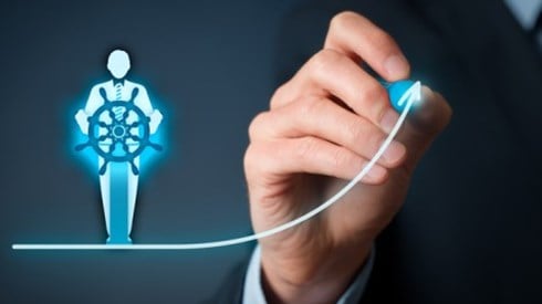 Under an icon of a businessman taking the helm of a ship a businessman draws a straight line that curves upward into an arrow