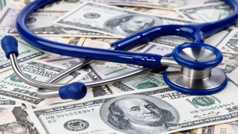 A stethoscope laying on a pile of money
