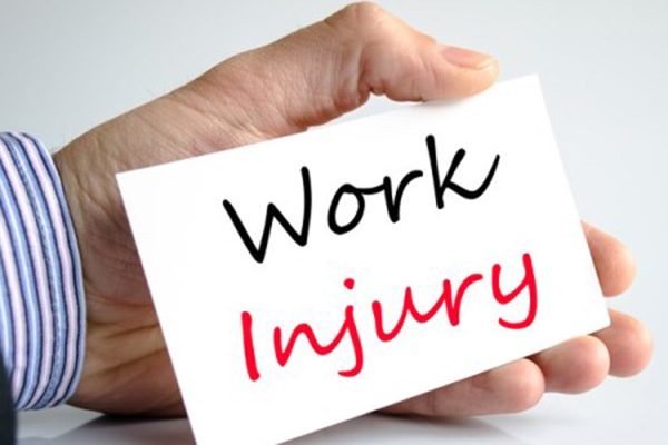 Hand holding card with the words Work Injury printed on it in black and red type