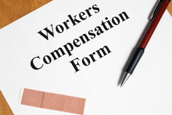 Workers Compensation Claim Form cover page with a pen and an adhesive bandage.