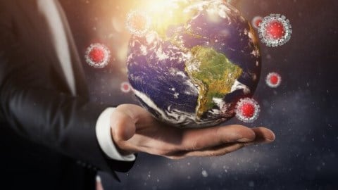 Man holding globe with COVID-19 virus around it