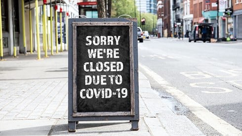 Store sidewalk sign reads Sorry we're closed due to COVID-19