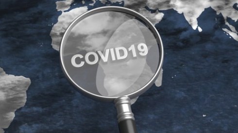 Over a flat globe a magnifying glass with COVID19 printed on the lens is focusing on Africa