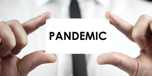 Business card with word Pandemic held in businessman's hands