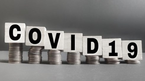 A building block for each letter of the term COVID19 is on top of a stack of coins descending in height