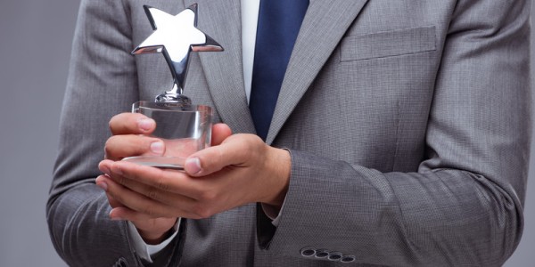 View of chest of a businessman holding a small trophy shaped like a star
