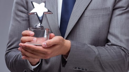 View of chest of a businessman holding a small trophy shaped like a star