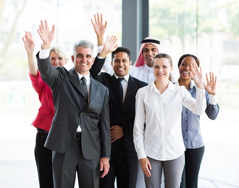 Multi-national group of male and female business professionals waving.