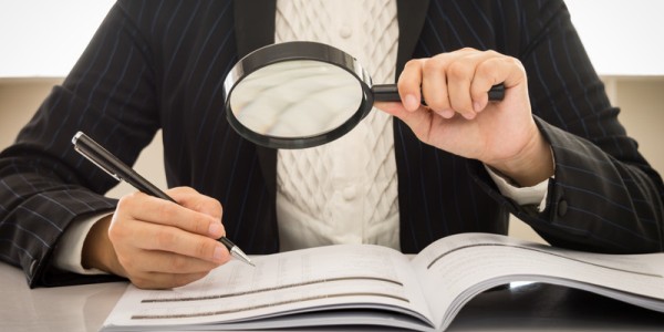 Business Woman Looking At Booklet With Magnifying Glass