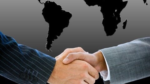 Businessman Shaking Hands in front of Outline of Southern Hemisphere