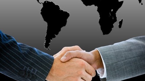 Businessman Shaking Hands in front of Outline of Southern Hemisphere