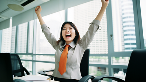 Happy businesswoman celebrates because of some accomplishment on her laptop