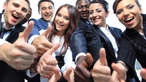 Smiling young business professionals giving thumbs up