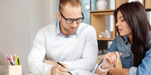 Millenial woman being coached by man in workplace