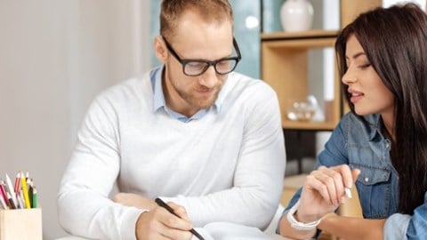 Millenial woman being coached by man in workplace