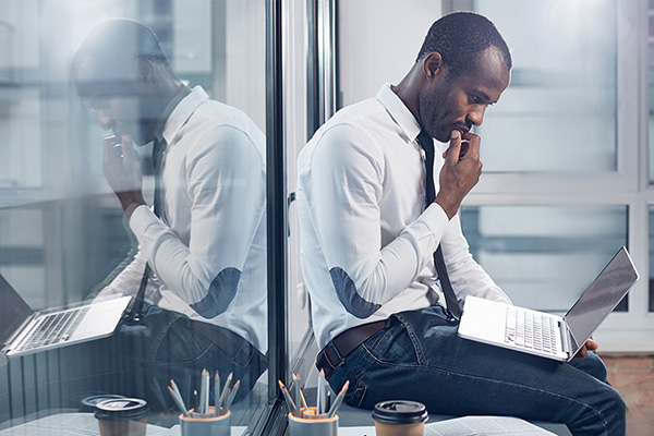Office worker contemplating online educational certifications while looking at this laptop