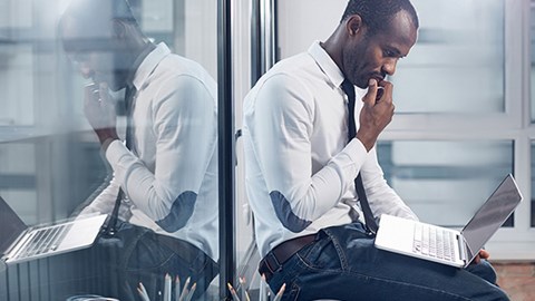 Businessman sitting on the floor looking at a laptop