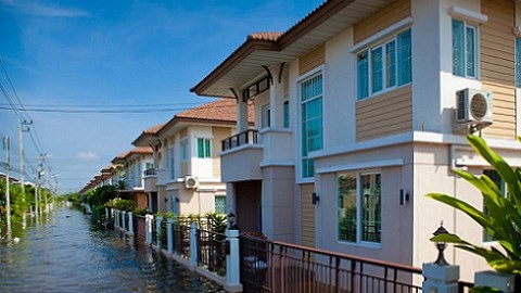 Residential street with two story buildings with flood waters nearing the ground floor
