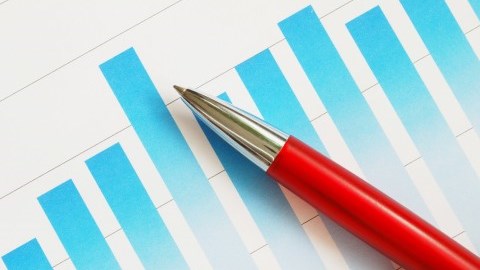 Red pen laying on a blue bar graph printed on a piece of white paper