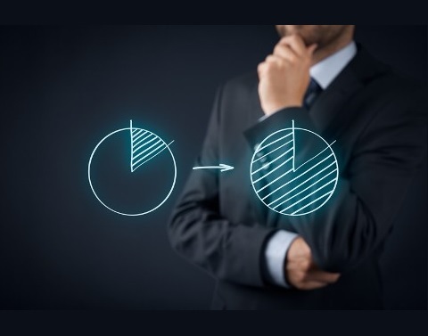 Man viewing a pie chart drawing with one-eighth shaded and an arrow pointing to another pie chart with seven-eighths shaded