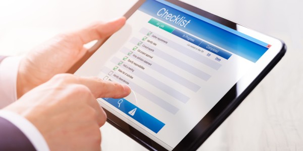Business Man Looking At Checklist On Tablet
