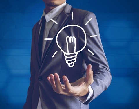 Businessman holding a drawn lightbulb with illumination lines