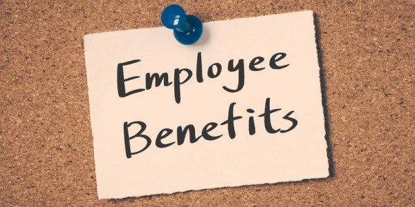 The words Employee Benefits pinned to a cork board with a blue push pin