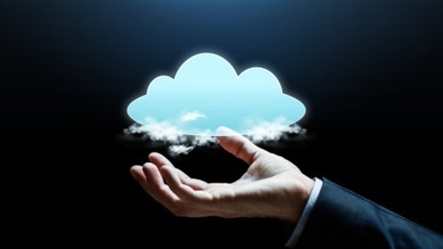 A business professional´s hand holding literal clouds and a larger animated cloud