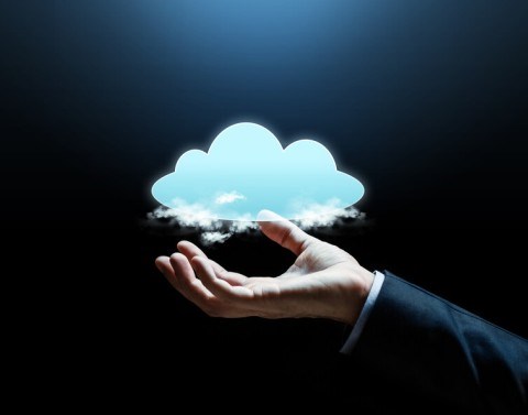 A business professional´s hand holding literal clouds and a larger animated cloud
