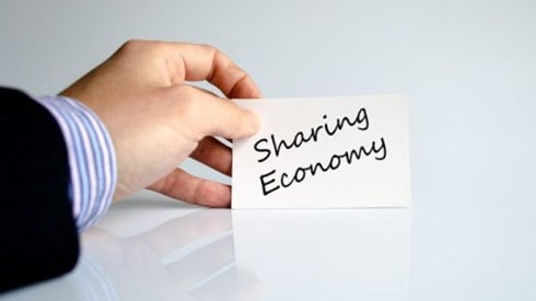 Hand holding paper with sharing economy text