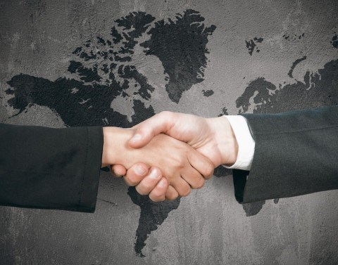 Handshake In Front Of Flat World Map