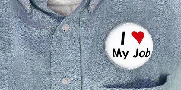 Closeup of a man´s shirt with a bubble pinback button that says I Love My Job with love symbolized by a red heart