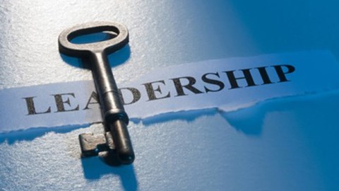A skeleton key is lying on top of a torn piece of paper with the word LEADERSHIP.