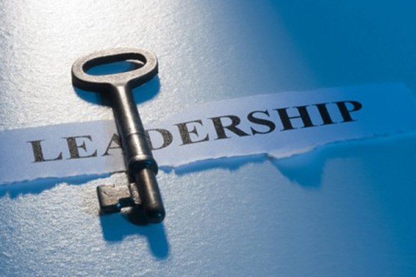 A skeleton key is lying on top of a torn piece of paper with the word LEADERSHIP.