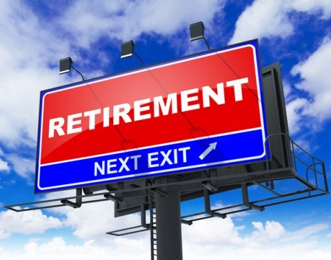 Highway sign of a red rectangle with the word RETIREMENT and below a smaller rectangle with the words NEXT EXIT and an arrow
