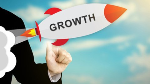 An animated rocket with the word GROWTH on it is launched by a business professional and directed upwards toward the sun