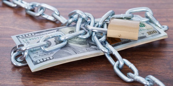 Stack of hundred dollar bills wrapped in chains and padlocked
