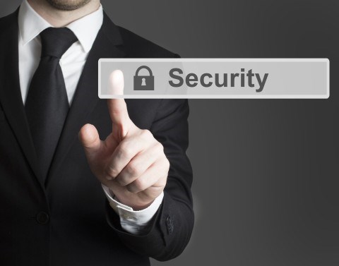 Businessman in a black suit pressing finger on a small gray lightly shaded sign with the word Security and Lock in black