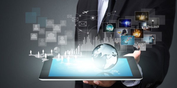 In a man´s hand is a tablet with a hologram of people, the globe, statistics, and networking technology above the display