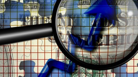 A magnifying glass looking at an increasing blue arrow with a dollar puzzle piece background