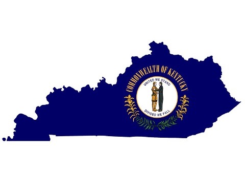 The Kentucky map is cut out of its navy-blue flag and shows a white circle with a pioneer and a statesman embracing.