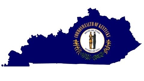 The Kentucky map is cut out of its navy-blue flag and shows a white circle with a pioneer and a statesman embracing.