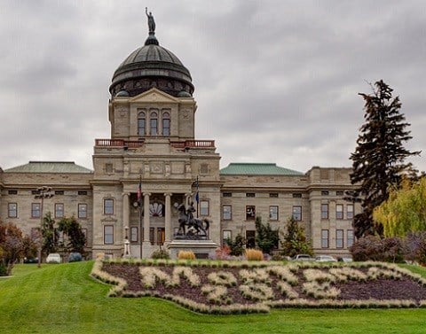 Montana capitol building on beautiful green landscaped grounds with cloudy skies in background