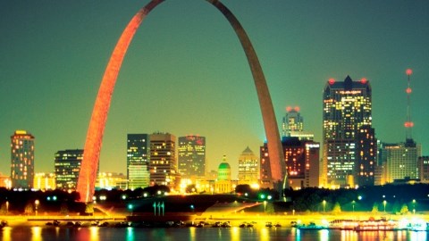 A nighttime view of St Louis and the Arch from across the waters of the Mississippi River