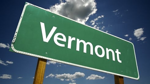 A green highway sign with the word Vermont on it